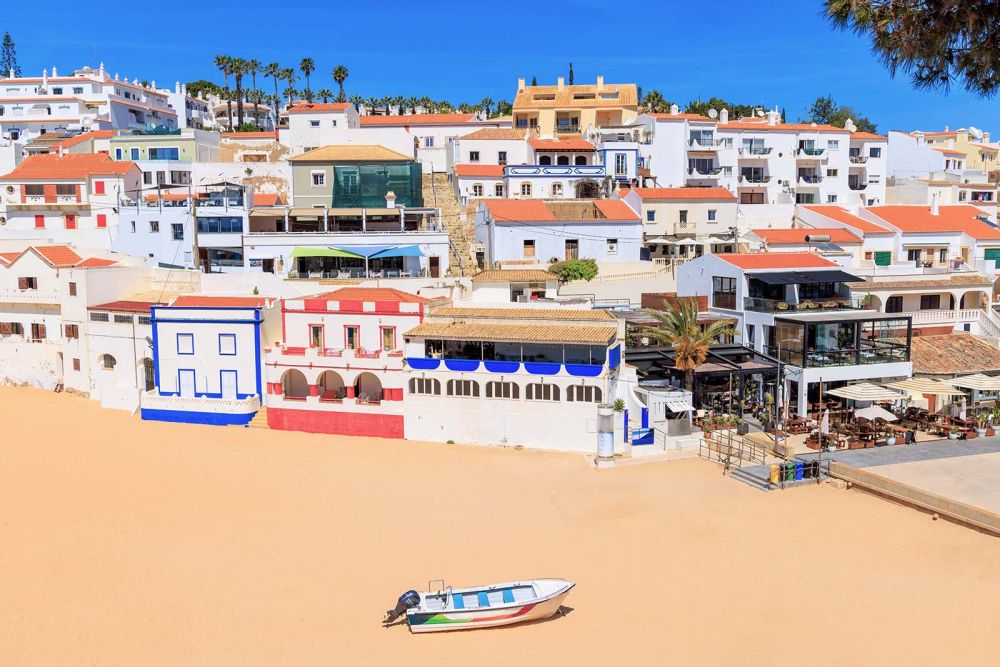 Gekleurde huisjes en restaurant langs het strand Carvoeiro